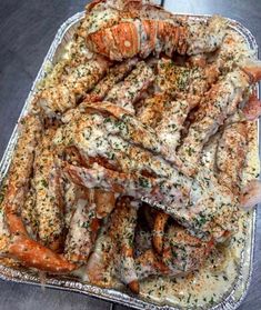 cooked lobsters with garlic and parsley in a baking dish on a table top