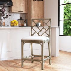 a white counter top sitting next to a wooden chair in front of a kitchen window