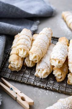 several pastries sitting on a cooling rack with wooden utensils next to them