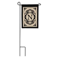 a black and white flag with the letter n hanging from it's side on a metal pole