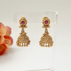 Lightweight, small simple gold jhumkas! These lovely jhumkas come in a traditional gold accented design and hanging pearls. The modern design adds traditional flair to any occasion. Length: 2" | Width .5" Items are carefully packed and ready for gifting. All pictures are taken in natural light please allow for slight variations in color due to camera settings. Jewelry Care ✨Protect your jewelry in a closed box or pouch   ✨Wear jewelry after you have applied lotion or perfume ✨Gently buff with a soft cotton cloth  Visit our website: www.desimoon.etsy.com Thank you for visiting and hope you enjoy my shop! Luxury Hand-set Temple Jewelry Jhumkas, Old Buttalu Earrings Gold, Luxury Temple Jewelry Jhumkas For Ceremonial Occasions, Cheap Traditional Gold Danglers, Small Gold Jhumka, South Indian Earrings, Temple Earrings, Gold Jhumkas, Gold Jhumka