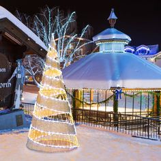 a lighted christmas tree in front of a building