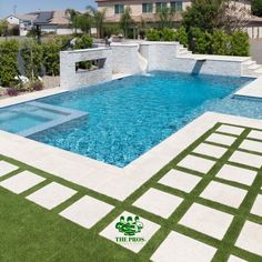 an empty swimming pool in the middle of a backyard with grass and white tiles on the ground