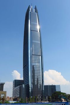 a very tall building sitting in the middle of a body of water next to other buildings