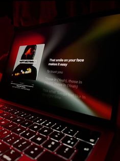 an open laptop computer sitting on top of a red table next to a black keyboard