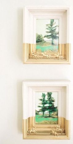 two framed pictures hang on the wall next to each other, one with a pine tree in it