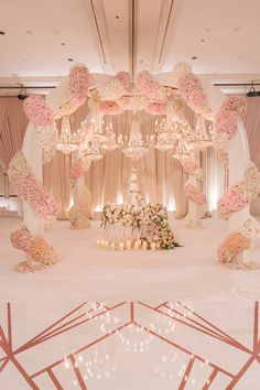 a wedding ceremony with flowers and candles on the table in front of an elaborate chandelier