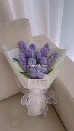 a bouquet of purple flowers sitting on top of a couch