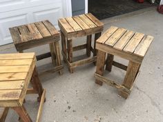 three wooden stools sitting next to each other in front of a garage door