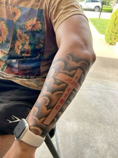 a man with a cross tattoo on his arm