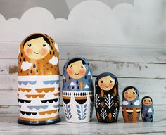 an assortment of nesting dolls sitting on top of a white wooden table next to each other