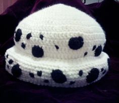 two crocheted hats with black dots on them