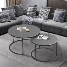 a living room with grey couches and white coffee table in front of a window