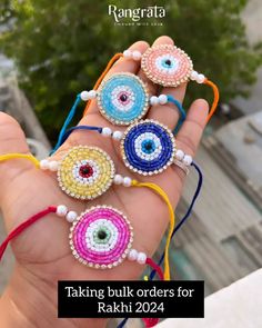 the hand is holding several colorful beads