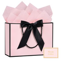 a pink gift bag with a black ribbon