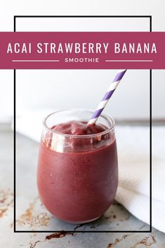 a smoothie in a glass with a purple and white striped straw sticking out of it