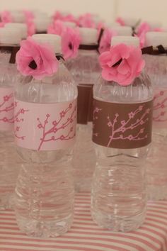 some water bottles with flowers in them on a table