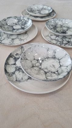 six white and black marbled plates on a table