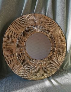 a round mirror sitting on top of a bed