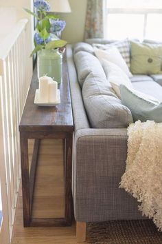 a living room with a couch, coffee table and flowers in a vase on it