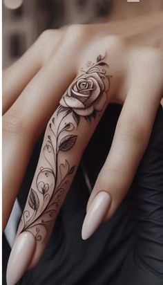 a woman's hand with a rose tattoo on it