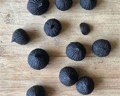 some black fruit sitting on top of a wooden table