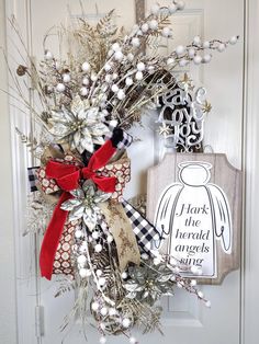 a wreath is hanging on the front door with an angel ornament next to it