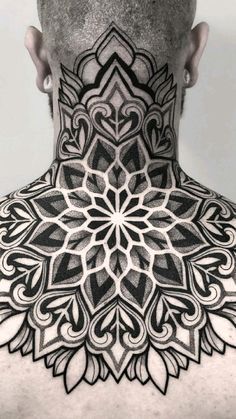 the back of a man's neck with an intricate tattoo design on his chest