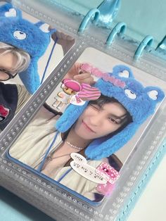 two pictures of the same person with blue hair, one wearing a cat hat and holding a cell phone up to her ear