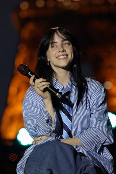 a woman wearing a tie and holding a microphone