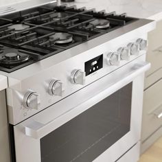 a white stove top oven sitting inside of a kitchen next to cabinets and drawers with knobs