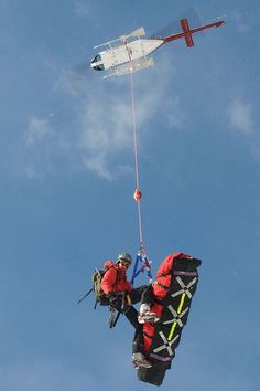 a man is parachuting in the sky with an airplane above him and another person below him