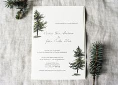 a wedding card with pine trees on it