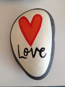 a rock with the word love painted on it and a red heart in the center