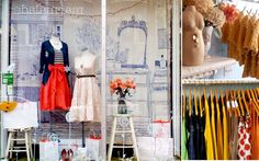 there are many dresses on display in this store window, and one is for sale