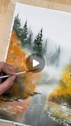 someone is painting an autumn scene with water and trees