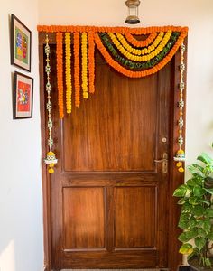 a wooden door decorated with orange and yellow garland