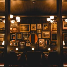 a dimly lit dining room with pictures on the wall and candles in front of it