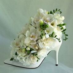 a shoe decorated with white flowers and greenery