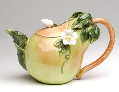 a green tea pot with white flowers on it