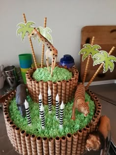 a cake made to look like a basket with animals and palm trees in it on a table