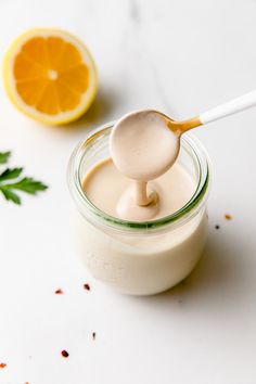 a spoon full of yogurt next to an orange