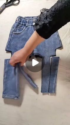 someone is cutting out some jeans with scissors