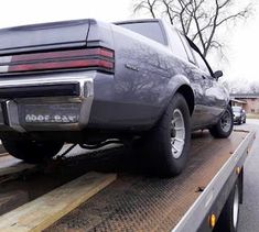 a car is on the back of a flatbed truck