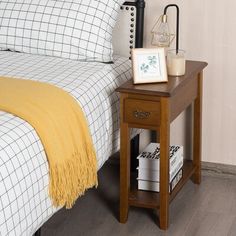 a bed with a wooden night stand next to it