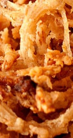 some food is stacked on top of each other in this close up photo with focus on the onion rings