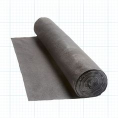 a rolled up piece of fabric on top of a sheet of graphite paper with a grid pattern in the background