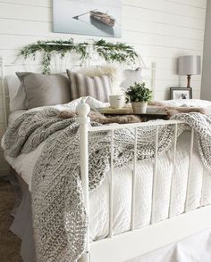 a white bed topped with pillows and blankets