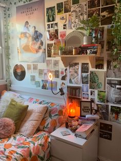 a bedroom with lots of pictures on the wall and a bed in front of it