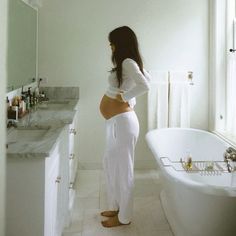 a woman standing in front of a bath tub